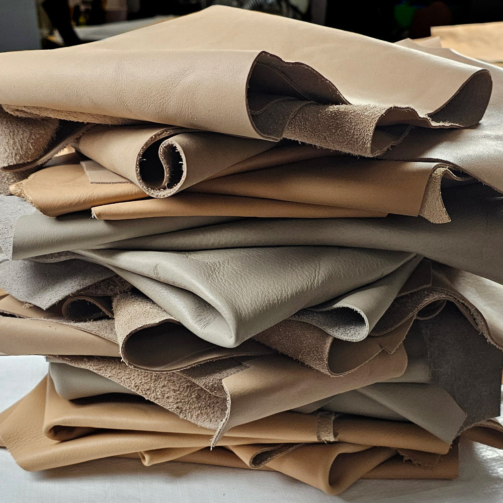 Assorted beige full-grain leather remnants with soft, natural tones for elegant leathercraft projects