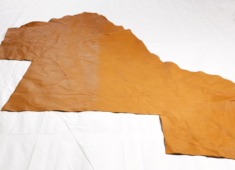 Coloured vegetable tanned leather offcuts in tan, saddle tan, and forest green