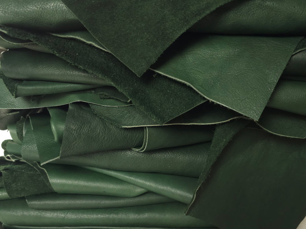 Forest Green leather remnants for crafts stacked on table
