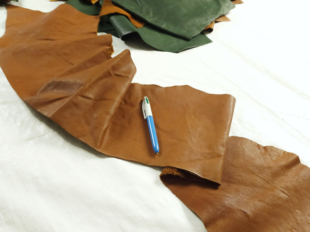 Tan, saddle tan, and forest green veg tanned leather pieces for small leatherwork

