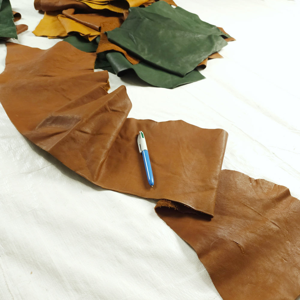 Tan, saddle tan, and forest green veg tanned leather pieces for small leatherwork

